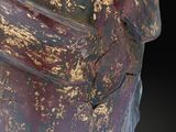 statue of a person with a red and gold paint on it ' s face