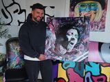 a man that is standing in front of some art