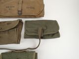 three military pouchs are lined up on a white surface