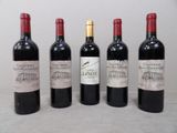 four bottles of red wine are lined up on a table