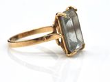 a close up of a gold ring with an emerald stone