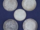 four silver coins, one of which is a sovereign and one of which is a sovereign