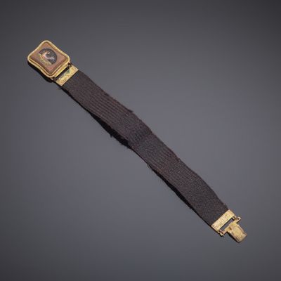 a gold plated wrist watch with a brown leather strap