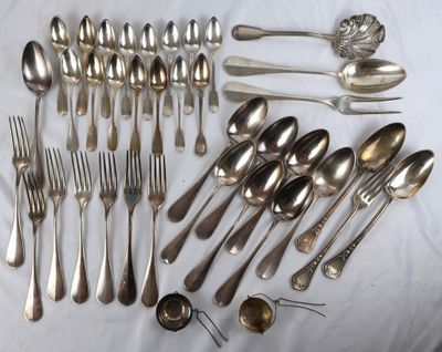 many spoons and forks laid out on a table