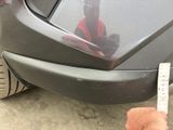 a person holding a sticker that is attached to a car
