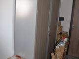 a refrigerator in the middle of a room with a lot of boxes on the floor