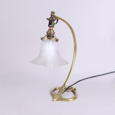 une lampe de table ancienne en laiton avec un abat-jour en verre, sur fond blanc