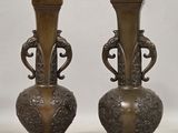 pair of antique bronze vases on a white background