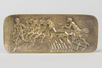 an image of a gold belt buckle with a horse and rider on it