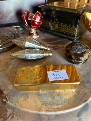 un lingot d'or posé sur une table à côté d'autres objets