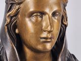 bronze statue of a woman with a hat on her head