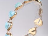 bracelet turquoise et or exposé sur un socle blanc