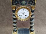 a clock that is sitting on a stand on a table