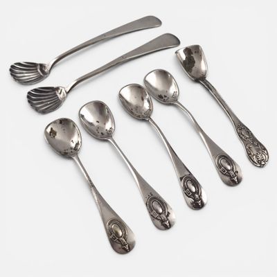 five spoons and two spoons on a white surface
