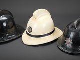 three hats are lined up in a row on a black surface
