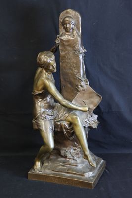 bronze statue of a woman sitting on a chair holding a book