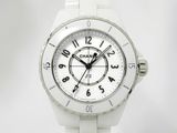 La montre est blanche et son cadran comporte des chiffres noirs.