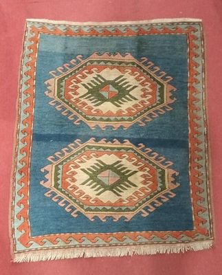 une image représentant un tapis bleu et orange sur fond rose