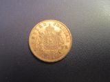a close up of a gold coin on a black surface