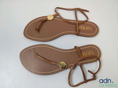 une photo représentant une paire de sandales pour femmes posées sur une surface blanche