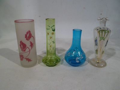 four different colored glass vases are lined up on a white surface