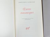 an open book with red writing on it sitting on a table