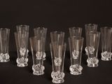 six verres à vin transparents sont alignés sur une surface noire