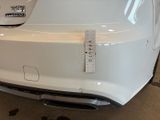 the rear end of a white car with a sticker on it ' s bumper