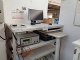 a computer desk with a monitor and other electronics on it