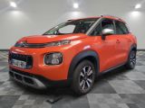 a bright orange citrole is parked on a checkered floor