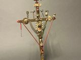 a metal sculpture of a cross with a bird on top of it