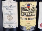 three bottles of red wine are lined up on a table