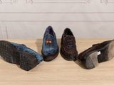 three pairs of men ' s shoes are lined up on a table