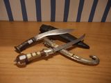 two knives that are sitting on a wooden table