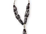 un collier de perles noires auquel est suspendu un pompon