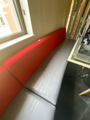 un banc rouge et noir dans une pièce dotée d'une fenêtre