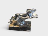 statue of a dog leaping over a marble block
