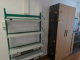 une étagère dans un coin d'une pièce, avec un réfrigérateur en arrière-plan