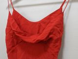 a red dress hanging on a hanger against a white wall