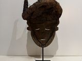 sculpture of a man ' s head on a stand in a white room