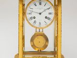a gold clock with roman numerals on the face