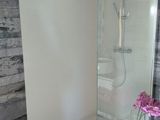 une douche avec une porte en verre dans une salle de bains