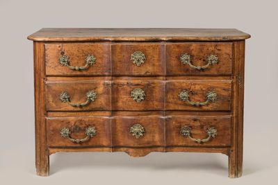 une commode ancienne avec des poignées et des boutons en laiton