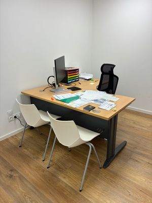 un bureau avec un ordinateur et une chaise dans une pièce