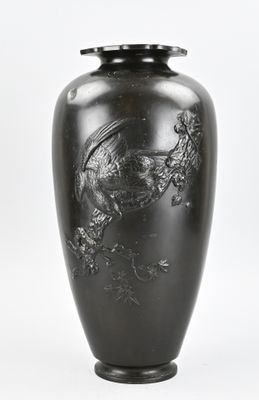 un vase noir orné d'un dragon sur fond blanc