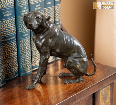 une statue représentant un chien assis au sommet d'une bibliothèque