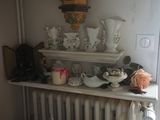 un radiateur dans un coin d'une pièce remplie de vases et de bougies