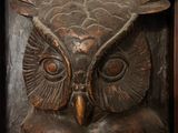 a carved owl that is sitting in a wooden frame