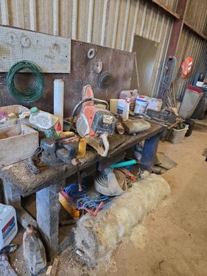 une photo d'un établi dans une grange, sur lequel sont posés des outils