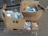 two boxes full of toothbrushes and toothpaste on a cart